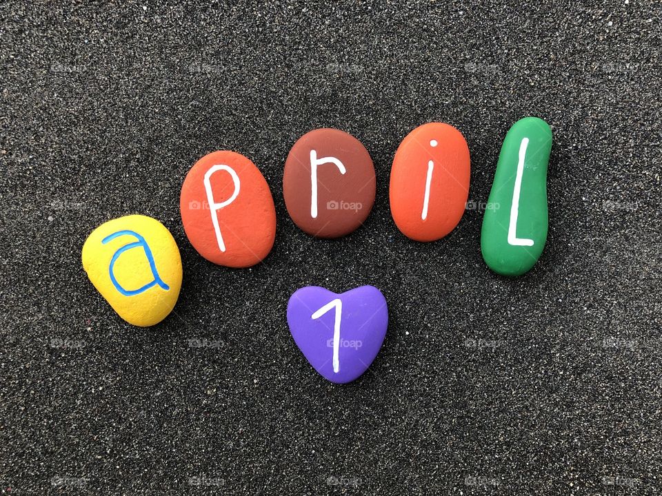1 April, calendar date with multicolored stones over black volcanic sand