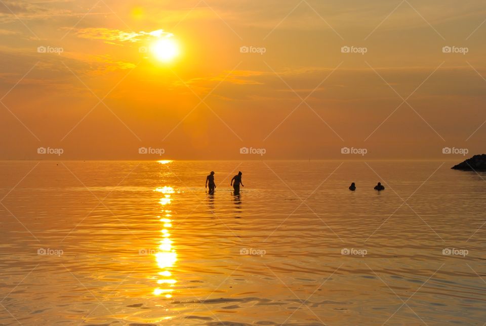 Silhouette of people in sea