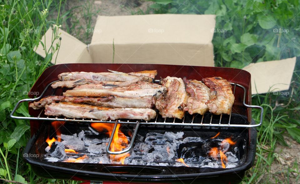 Meats on barbecue grill with flame