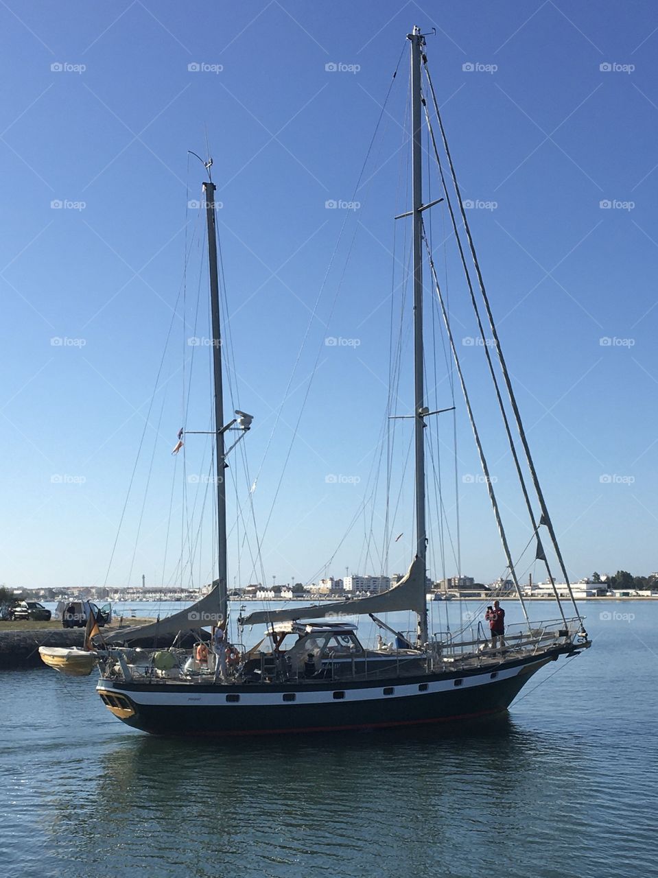 sailboat with 2 masts leaving the port