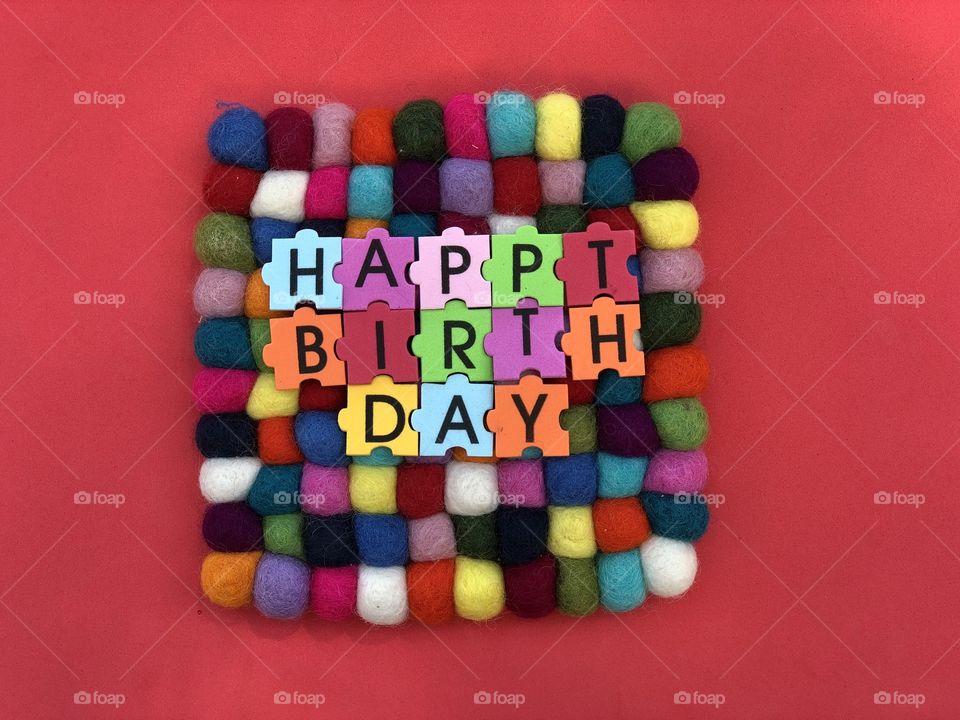 Happy Birthday text with multicolored puzzle letters