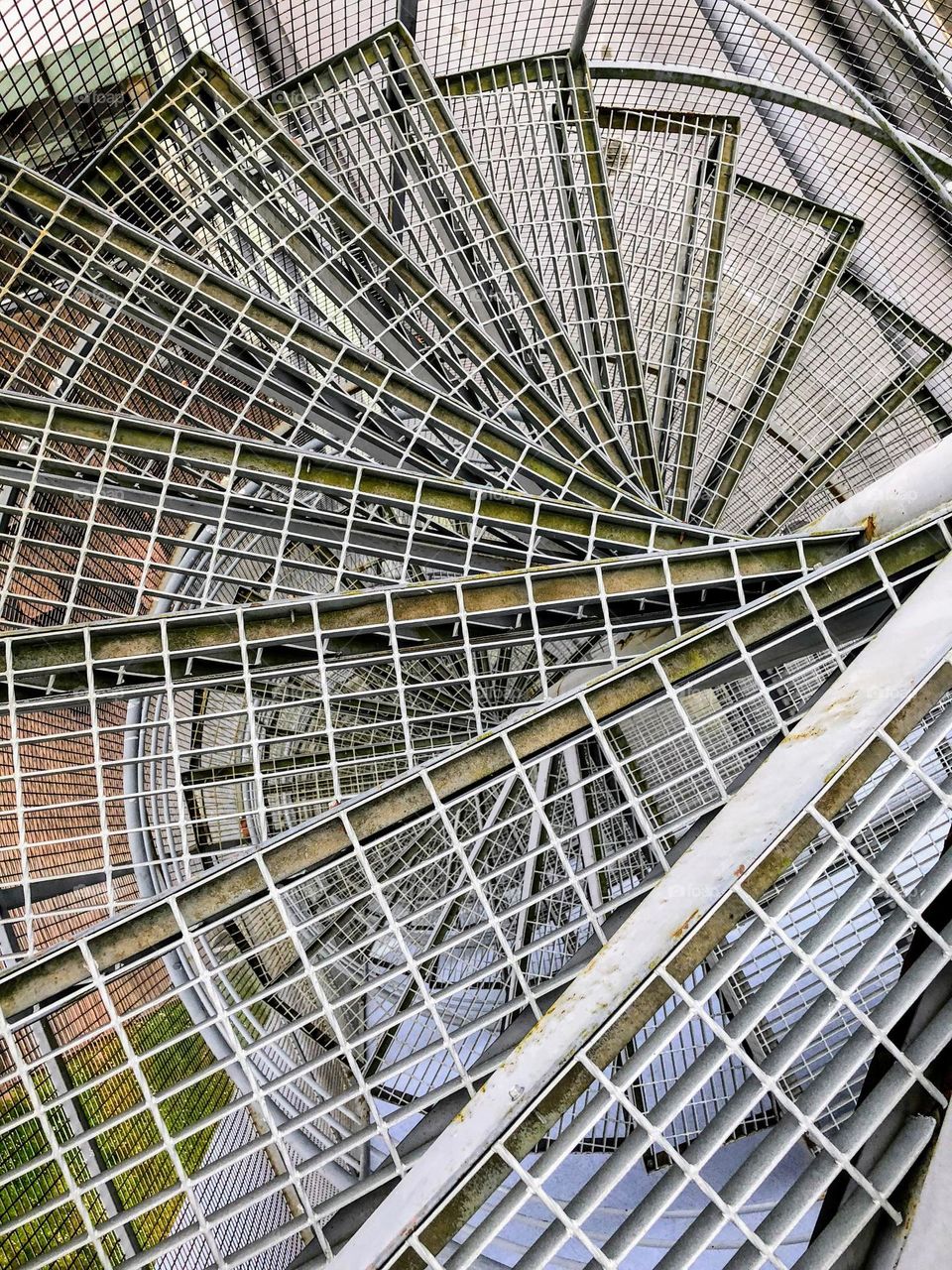 Close up view to the metal lattice round spiral steps of the staircase 