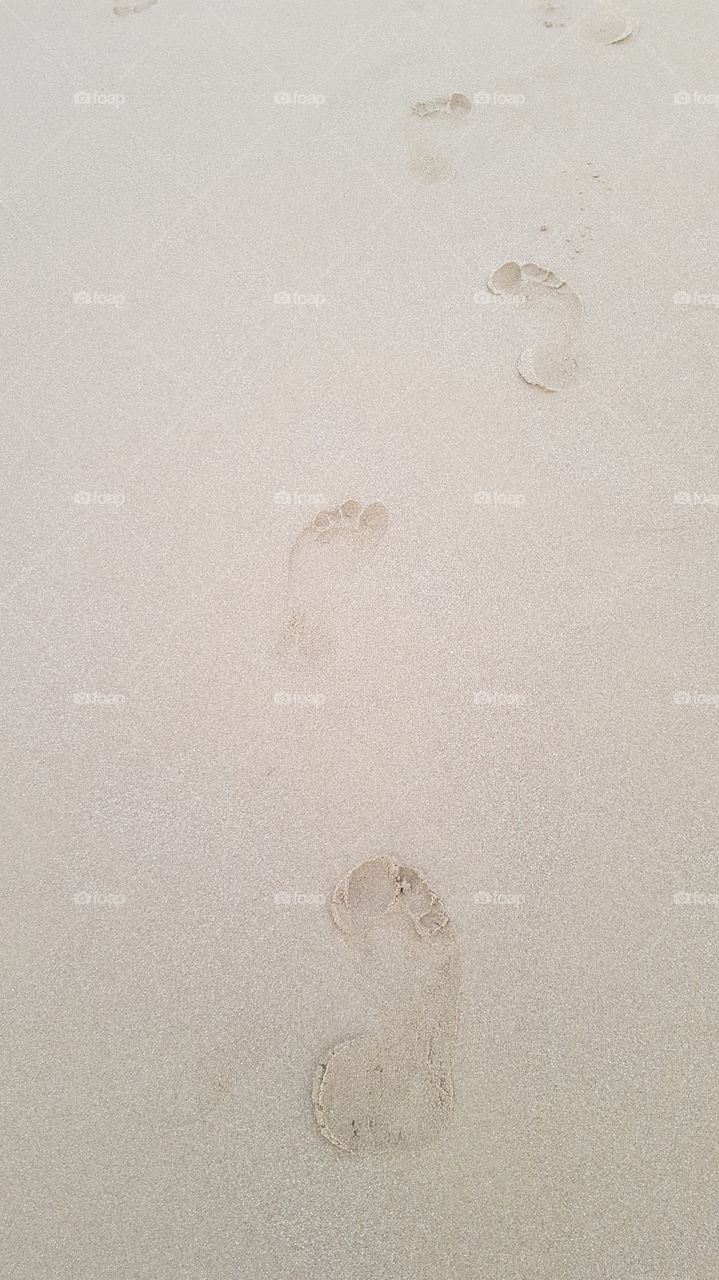 trace of feet on sand