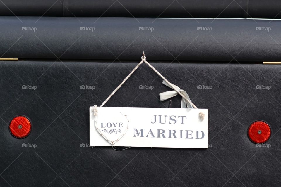 just married sign on the back of a wedding car