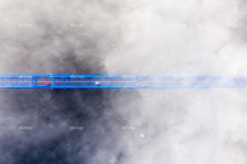 view from above on a metal bridge over river wraped in fog