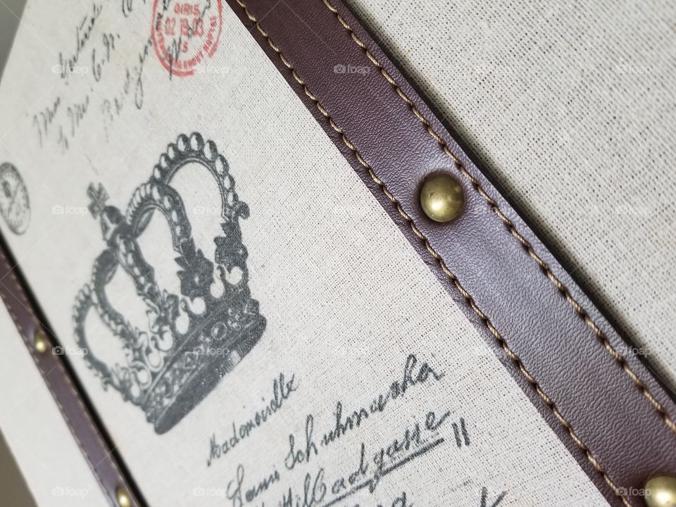 Angle take of Vintage, French style, leather banded case with crown, bronze rivets and burlap type material.