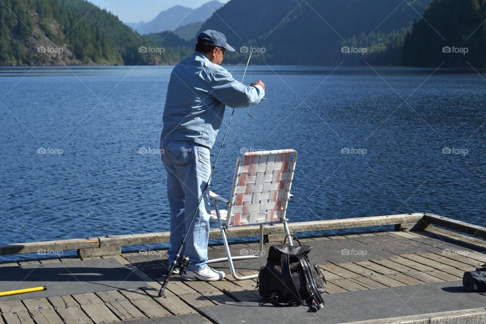 Fixing the line. Fishing off the dock at the lake