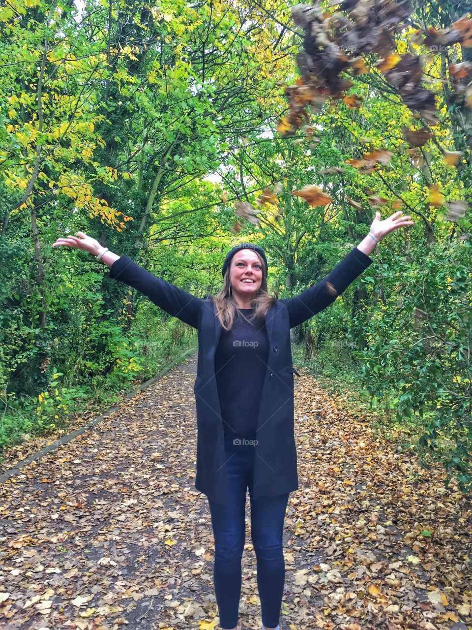 Smiling young woman standing in autumn