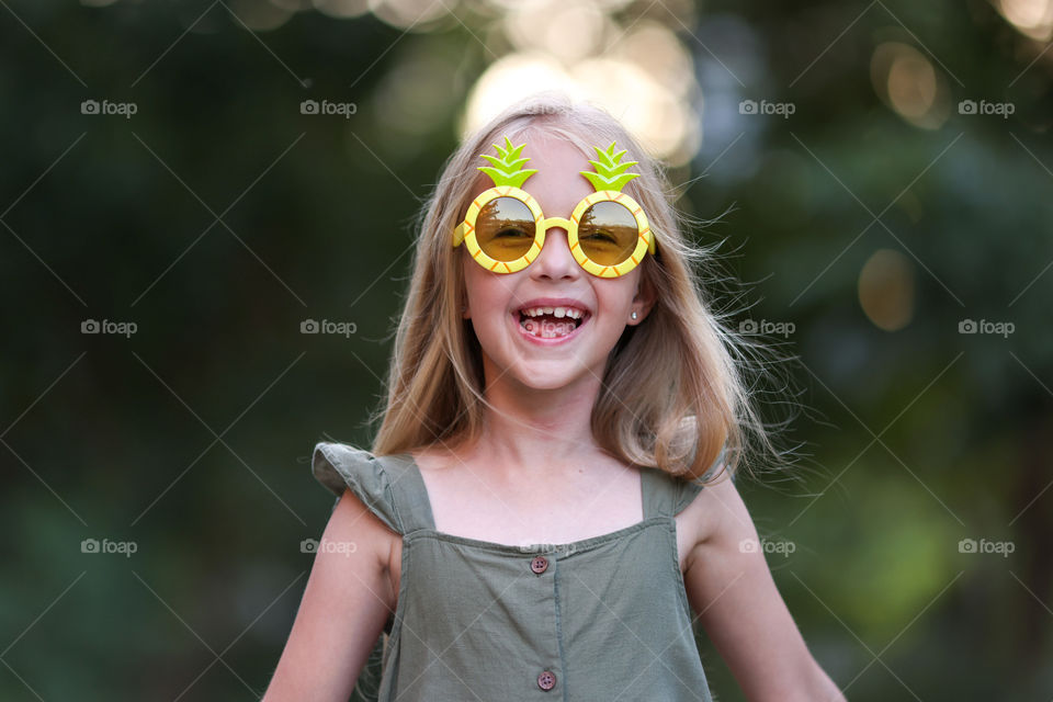 Summer portrait of happy little Caucasian girl with blonde hair outdoor 