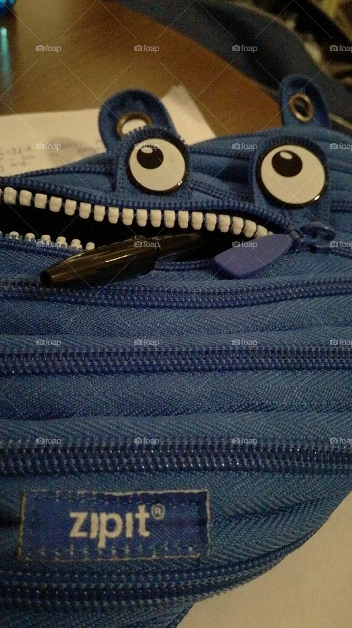 Pencil case with zip mouth guzzling a pen