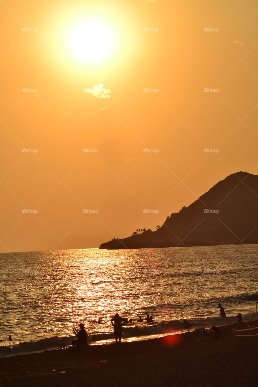 sunsetting over fishermen on the beach