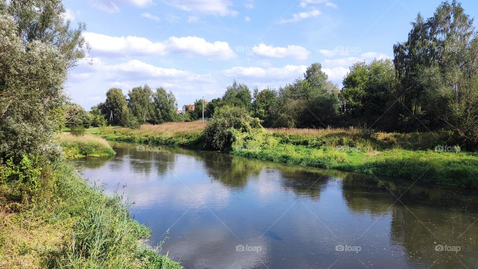 Summer. River. Countryside. Green trees. Fields