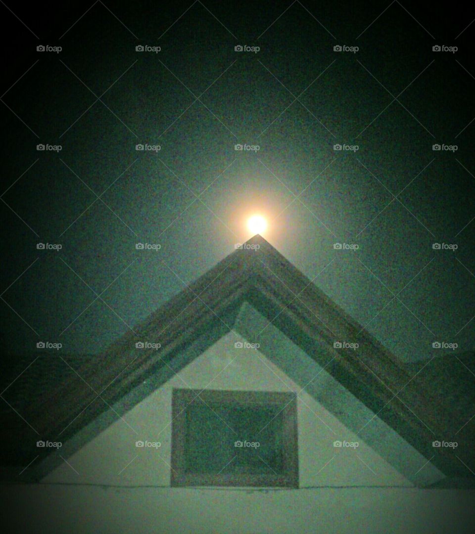 night shot of full moon. saw the moon so full. took a shot of it on top of our pointed roof