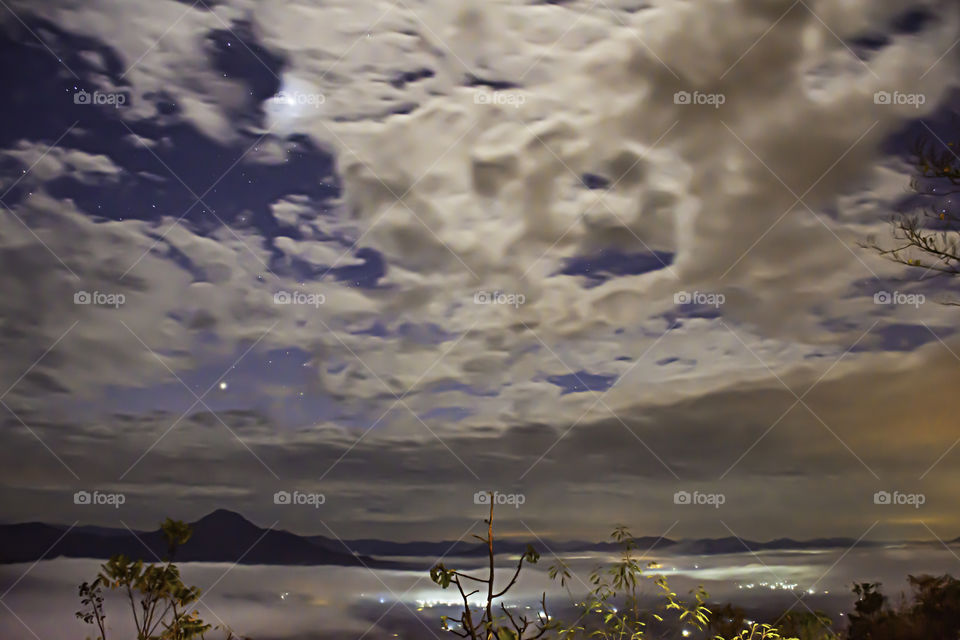 Sky with stars and the clouds are flowing Background fog and the mountain.