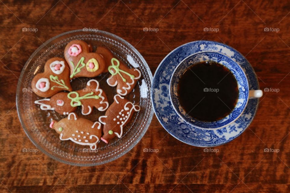 Top shot of Gingerbread in pretty colors and a cup of coffee on a wooden table