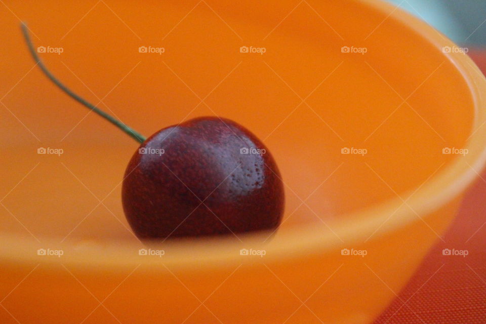 orange color bowl with cherry