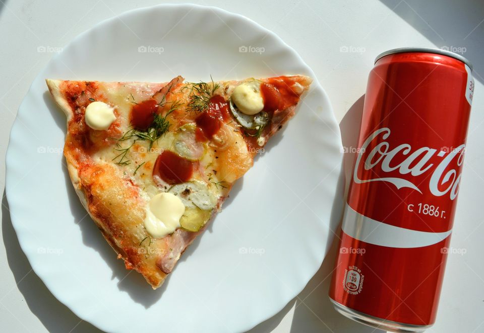 coca cola and pizza on a plate on a white top view background, tasty food and drink