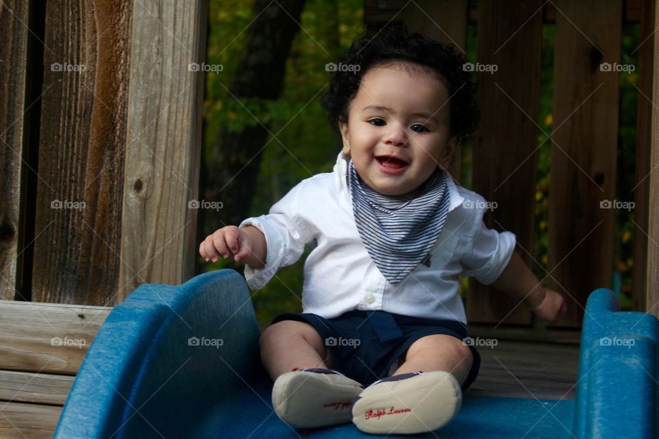 Time to slide . Happiness when he realize mommy got him at the end of the finish line of the slide . 