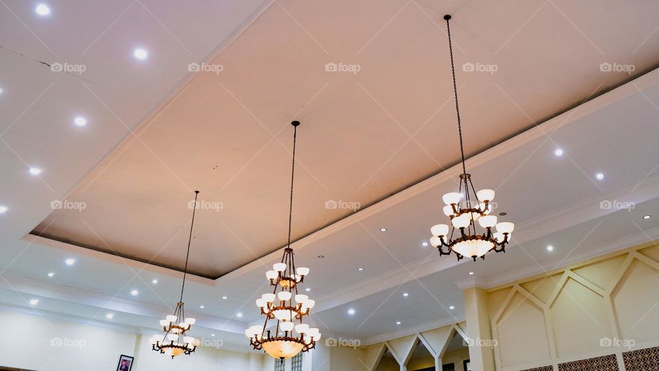 Portrait of a classic style indoor chandelier with many lights arranged upwards, the chandelier is suitable for the interior of a living room or family room.