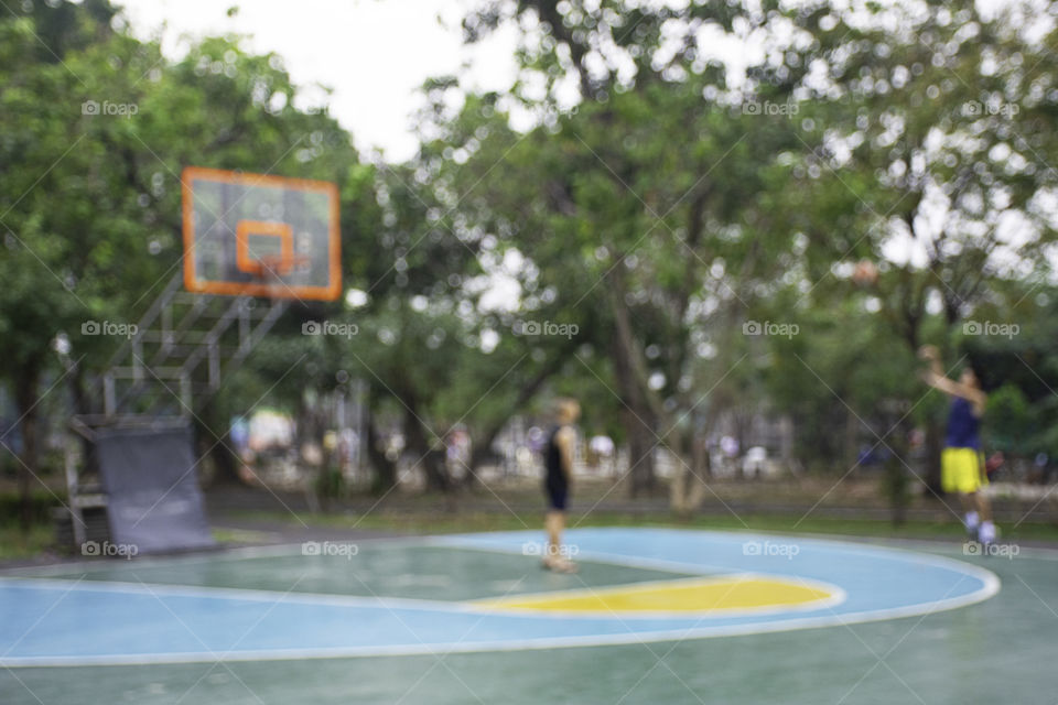 Blurry image teens playing basketball in the morning at BangYai Park , Nonthaburi in Thailand.