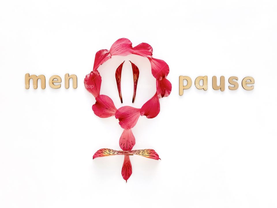 Word Menopause with wooden letters on white background, symbol with Alstroemeria petals