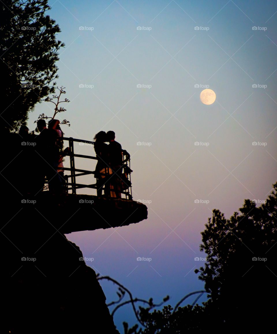 couple silhouette kissing under moonlight