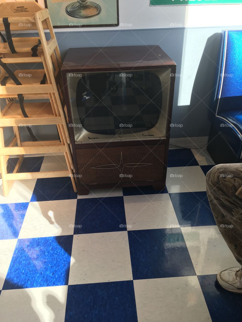 Old black and white t.v sitting in the ice cream shop. You can picture kids sitting around this.