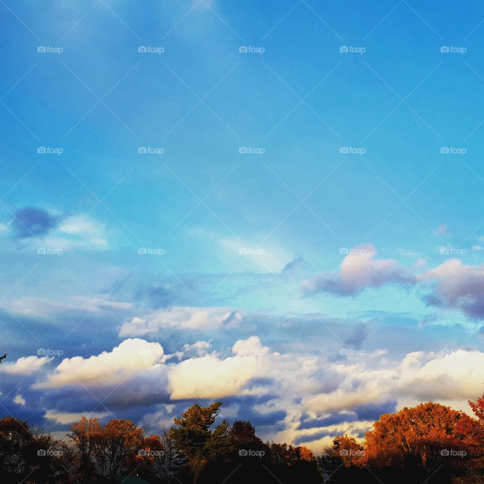clouds over the fall leaves changing colors