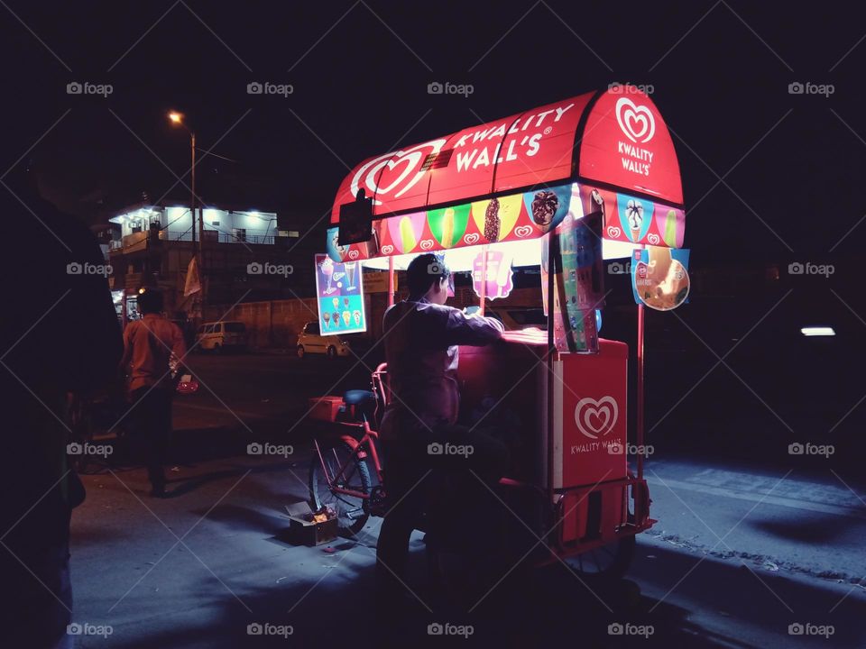 ice Cream vender selling ice cream during night.