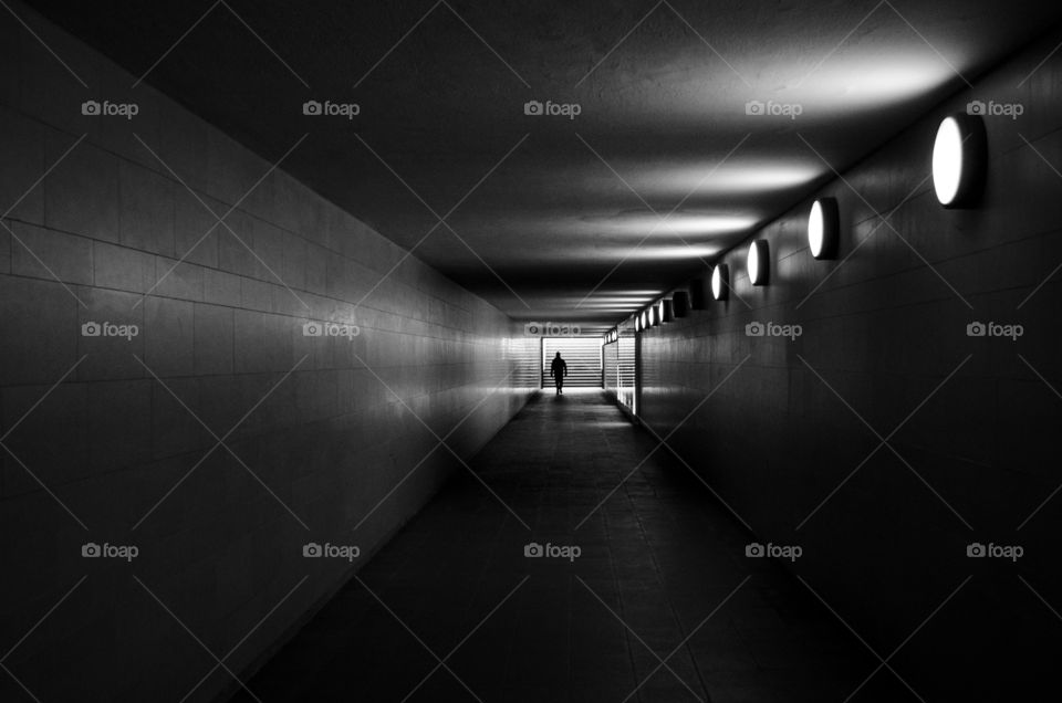 A man walking to the exit stairs on an underground corridor in Berlin, Germany.