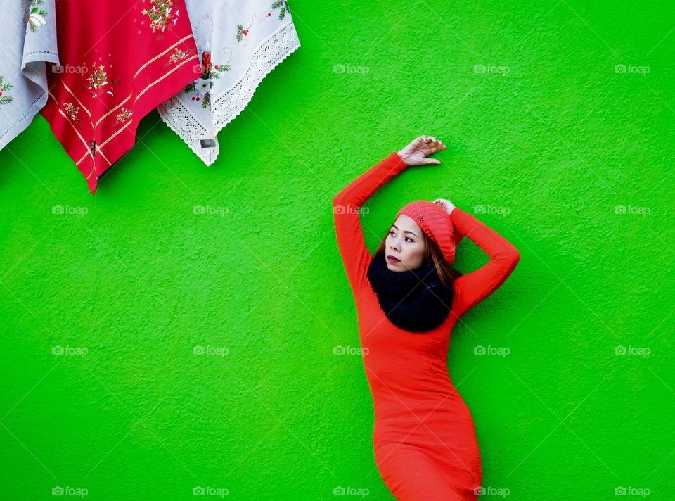 Asian woman standing near green background