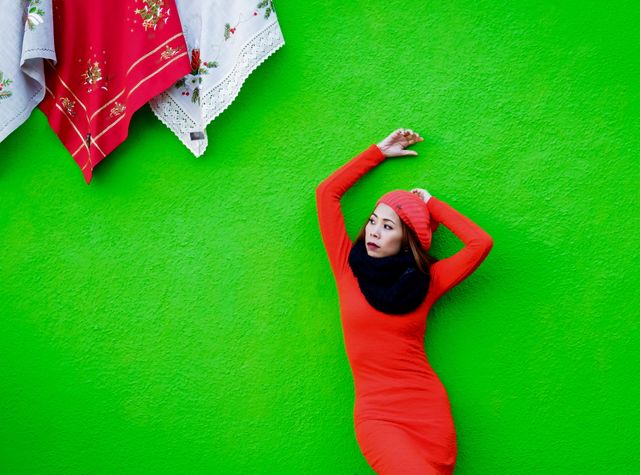 Asian woman standing near green background