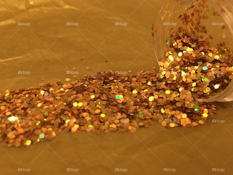 Close up view of gold glitter spilled across tissue paper