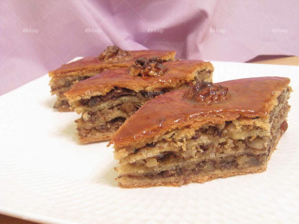 Armenian baklava with walnuts and honey sauce on the white plate