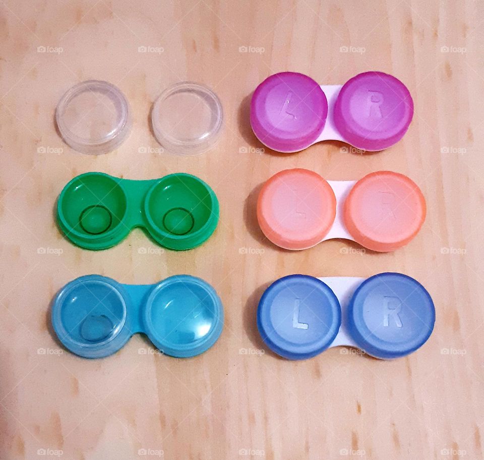 Close up the colour of soft contact lenses containers against on wooden background