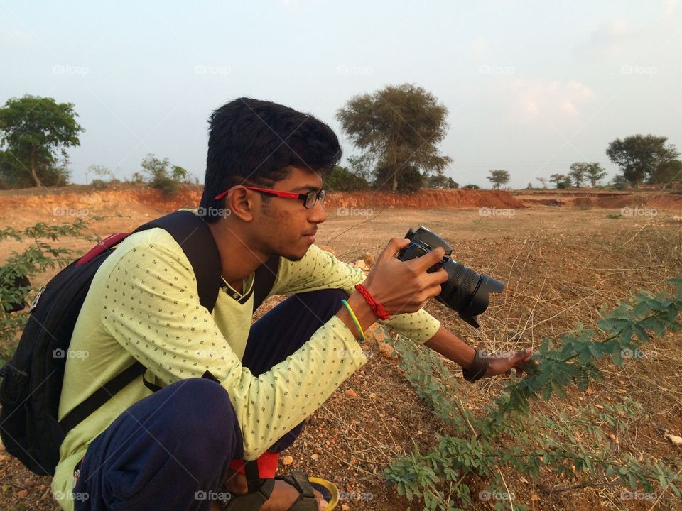 Young man taking photograph with camera