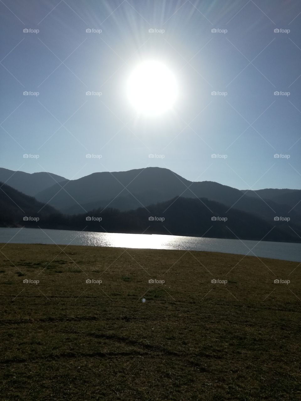 Sand, lake, mountains, sky and sun