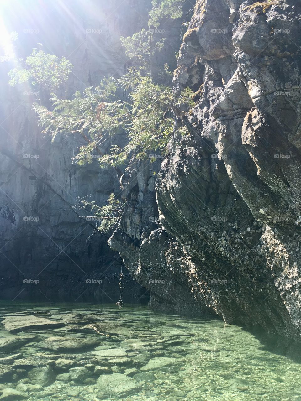 Rocks hanging over crystal clear water