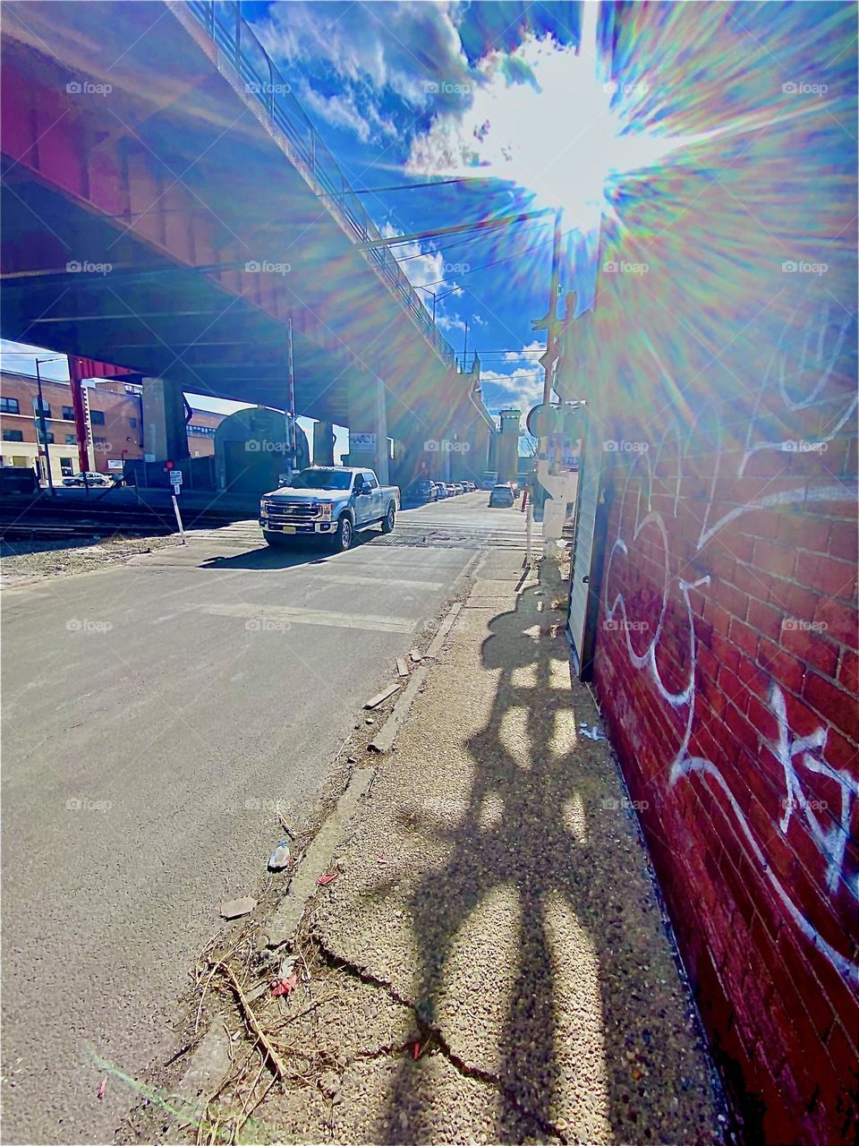 A beautiful refraction effect created by the sunlight on an early afternoon in January 2022. A large shadow cast by the “NO CROSSING” sign that prompts people to stop before the railway tracks in case of a train approaching. Hypnotic Productions