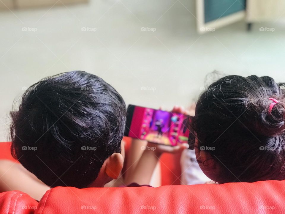 Kids together watching funny videos in phone 