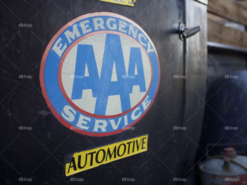 An old Triple A sign on the door of an old Ford Pickup truck 
