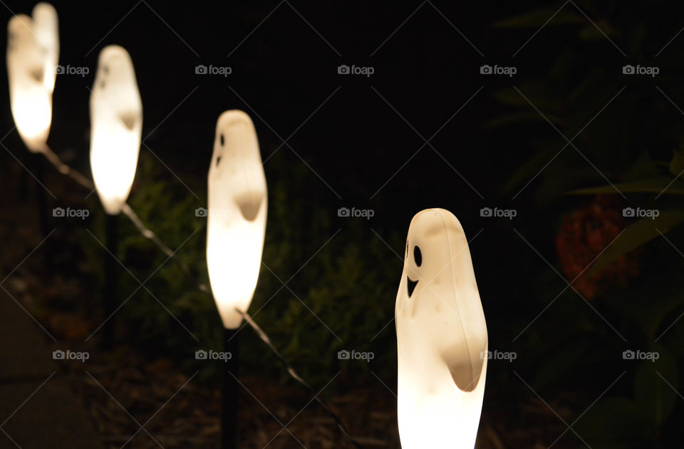 Close-up of ghost Halloween lights outdoors in the dark at night