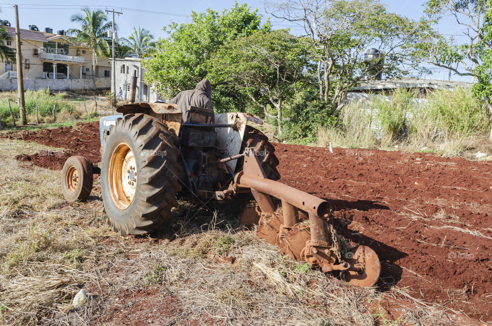 Farmer Ploughing Farmland With Tractor
