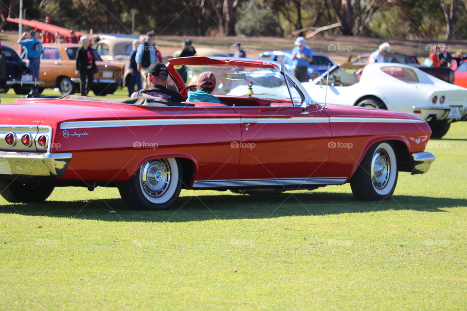 Red Chevy impala convertible classic car, at outdoor car show 