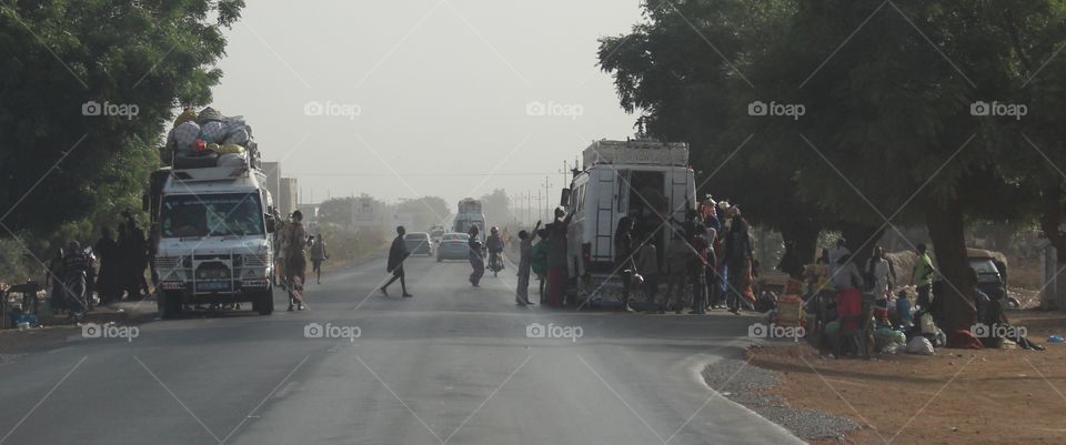 Roadside stop. Vendors try to sell their wares to bus passengers. Senegal.