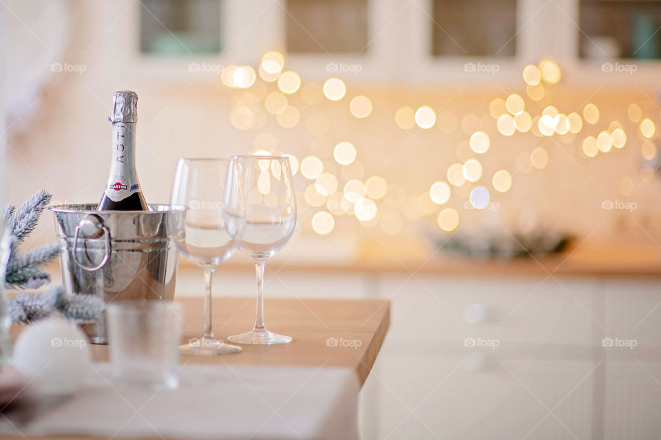 Festive winter cozy kitchen interior with garlands, decorations and gifts.  Christmas dinner at the decorated table.