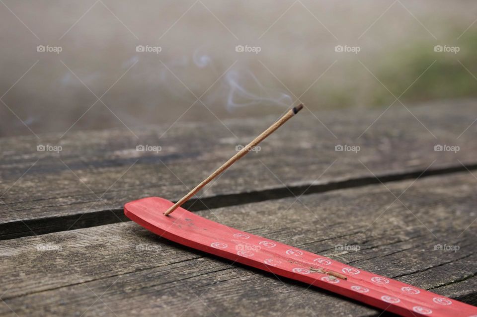 Close-up of incense burning in a wooden table 