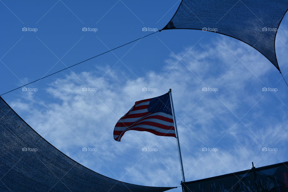 US flag viewed through sails in silhouette. 