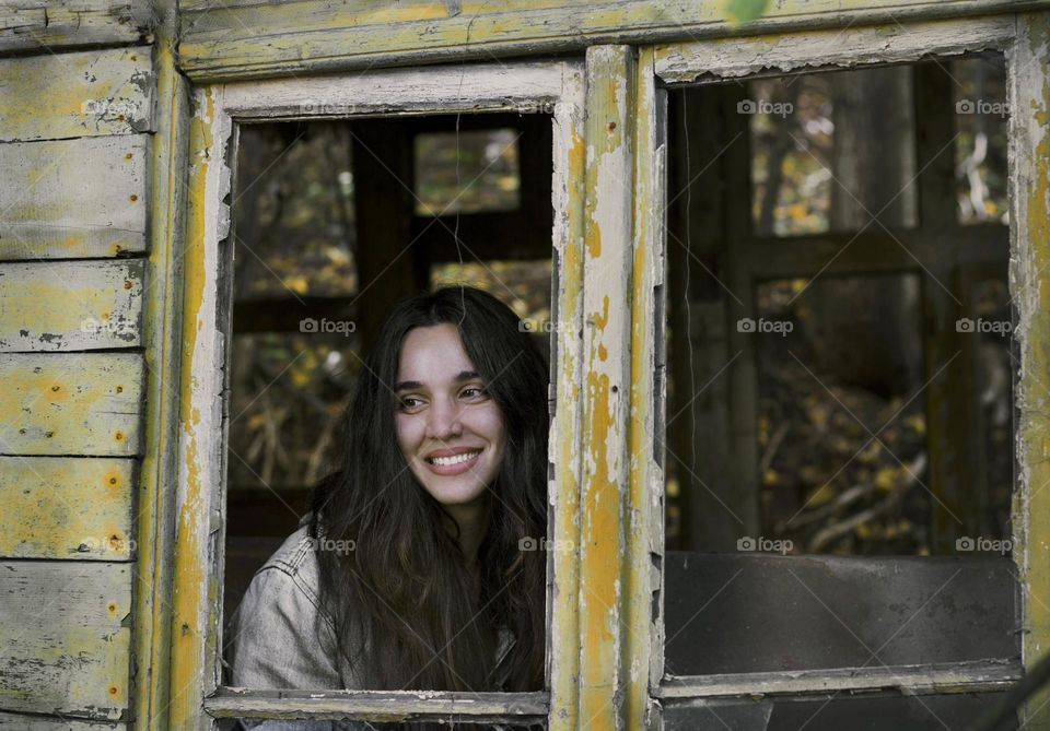 Beautiful smiling woman in country home window