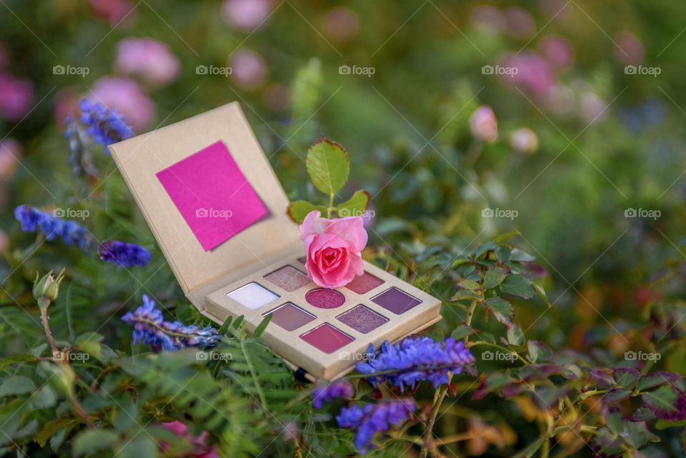 Eye shadow palette on floral background.